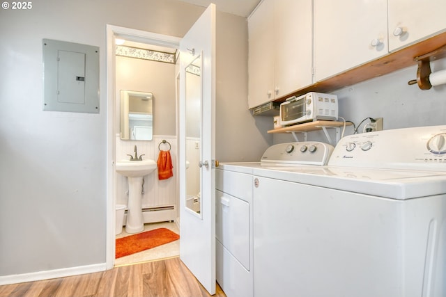 385 S Green St, Heppner, OR 97836 - laundry area with separate washer and dryer, electric panel, light wood-style floors, a baseboard heating unit, and cabinet space