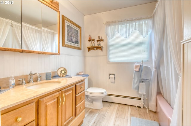 385 S Green St, Heppner, OR 97836 - bathroom with baseboard heating, vanity, shower / bathtub combination with curtain, and wood finished floors
