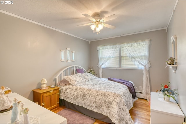 385 S Green St, Heppner, OR 97836 - bedroom featuring crown molding, light wood finished floors, baseboard heating, and a ceiling fan