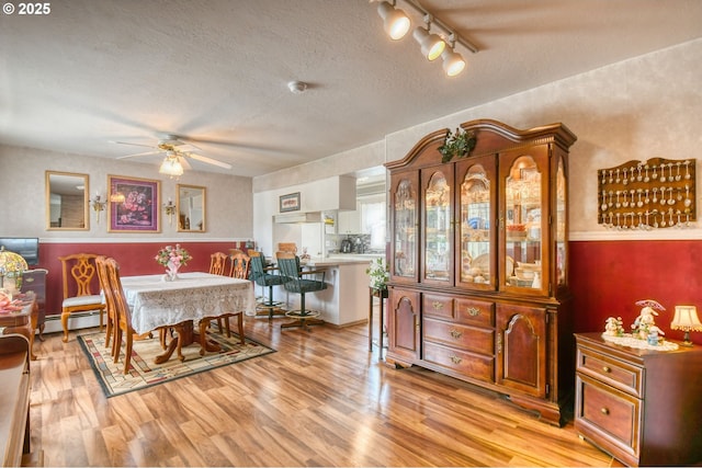 385 S Green St, Heppner, OR 97836 - dining area featuring a ceiling fan, light wood finished floors, a textured ceiling, rail lighting, and baseboard heating