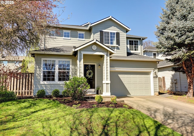 traditional-style house featuring concrete driveway, a front lawn, fence, and an attached garage