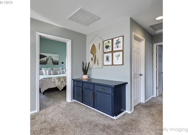 hallway featuring baseboards, carpet, and visible vents
