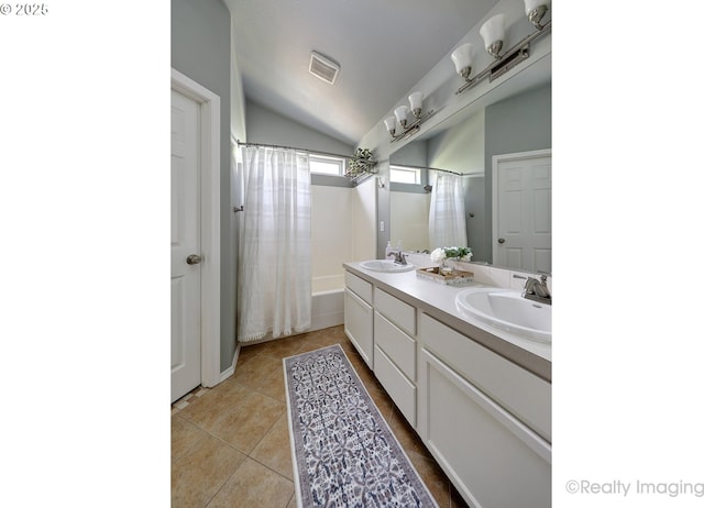 full bathroom featuring a sink, tile patterned floors, double vanity, and lofted ceiling