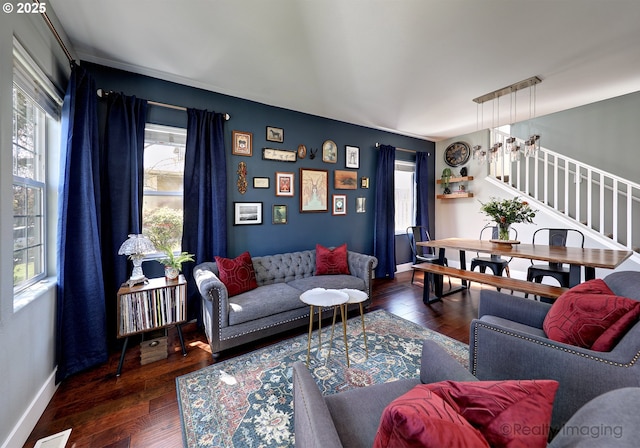 living area featuring stairway, visible vents, wood-type flooring, and baseboards