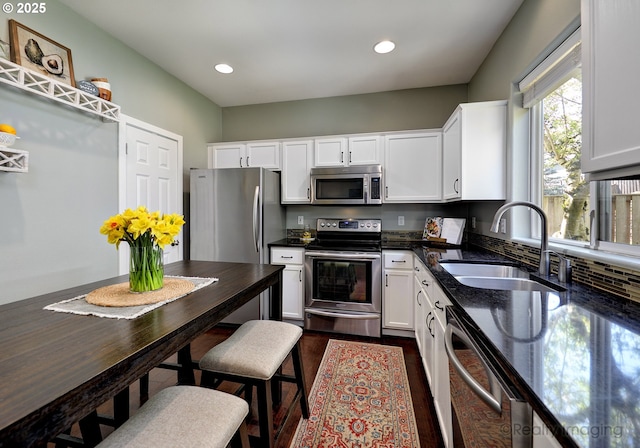 kitchen featuring white cabinets, recessed lighting, a sink, stainless steel appliances, and dark wood-style floors