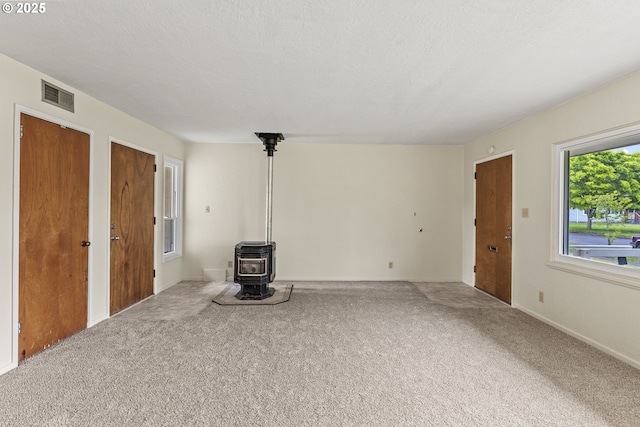 1041 19th Ave, Longview, WA 98632 - unfurnished living room with a wood stove, carpet floors, and baseboards