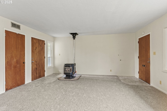1041 19th Ave, Longview, WA 98632 - unfurnished living room featuring carpet, a wood stove, and baseboards