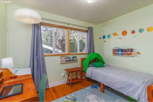 bedroom featuring hardwood / wood-style flooring and a textured ceiling