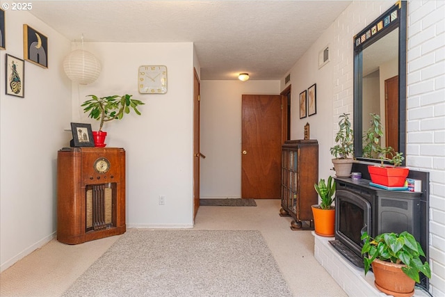 hallway with light carpet and a textured ceiling