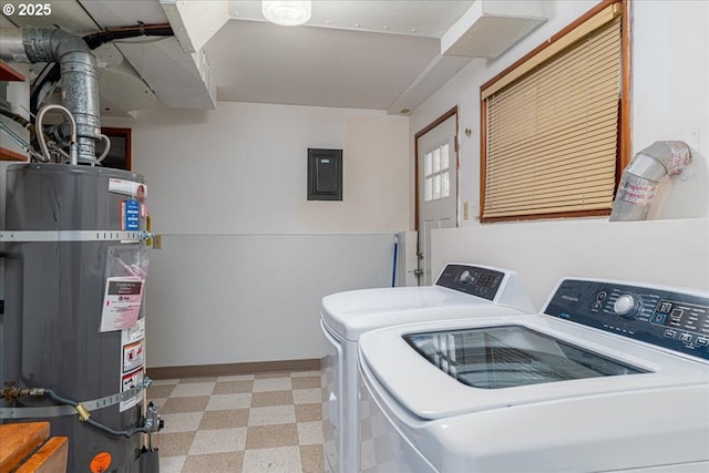 laundry area featuring electric panel, washing machine and clothes dryer, and strapped water heater