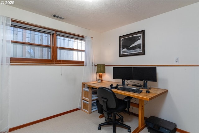 carpeted home office with a textured ceiling