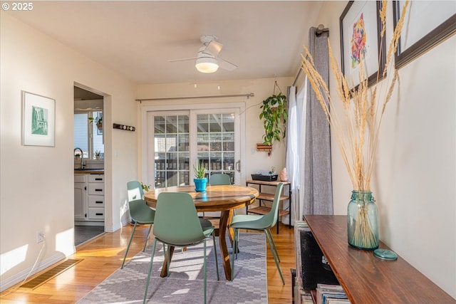 dining space featuring ceiling fan, sink, and hardwood / wood-style floors