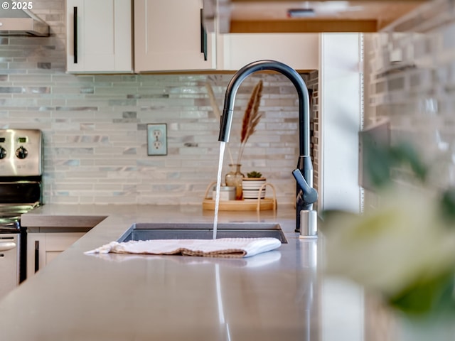 room details with range hood, backsplash, and white cabinets
