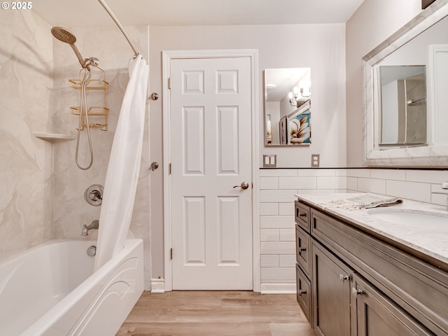 bathroom featuring wood finished floors, vanity, shower / tub combo with curtain, and tile walls