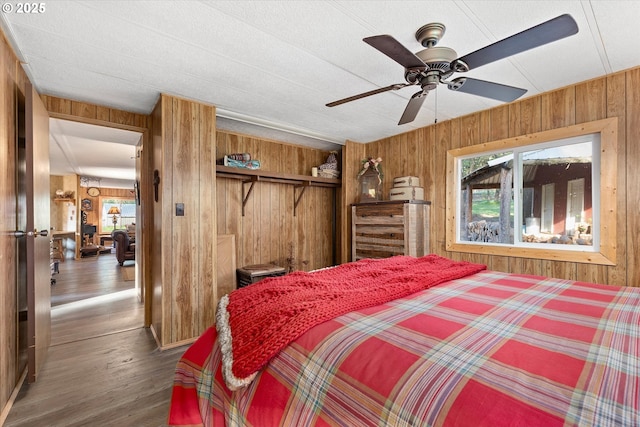 74576 Thompson Rd, Elgin, OR 97827 - bedroom featuring wooden walls, multiple windows, wood finished floors, a closet, and ceiling fan
