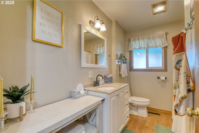 4303 SW Sheridan Ave, Pendleton, OR 97801 - full bath featuring vanity, toilet, wood finished floors, and a shower with shower curtain