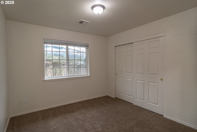 unfurnished bedroom featuring a closet, carpet floors, and a textured ceiling