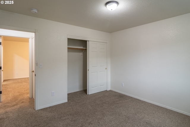 unfurnished bedroom featuring carpet floors, a textured ceiling, and a closet