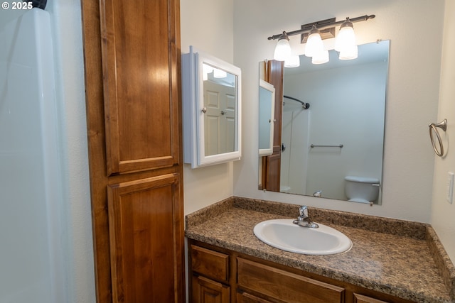 bathroom featuring a shower, vanity, and toilet