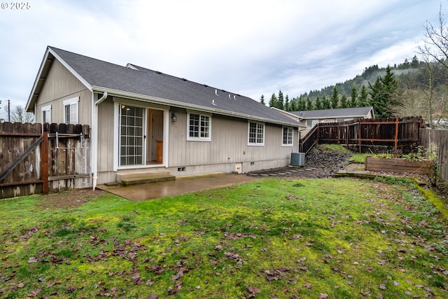 rear view of property with a lawn, a patio area, and central air condition unit