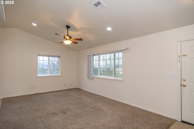 unfurnished room with a wealth of natural light, ceiling fan, light colored carpet, and vaulted ceiling