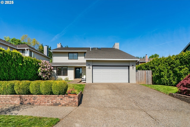 traditional-style home featuring a chimney, brick siding, fence, concrete driveway, and an attached garage