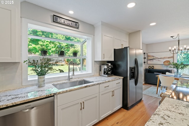 kitchen with white cabinets, stainless steel appliances, decorative backsplash, and a sink