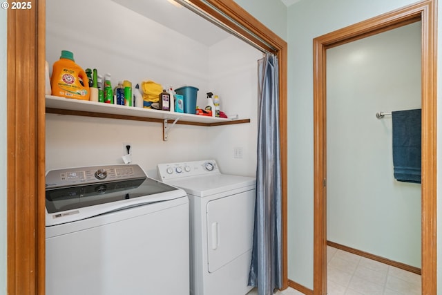clothes washing area with baseboards, washer and clothes dryer, and laundry area
