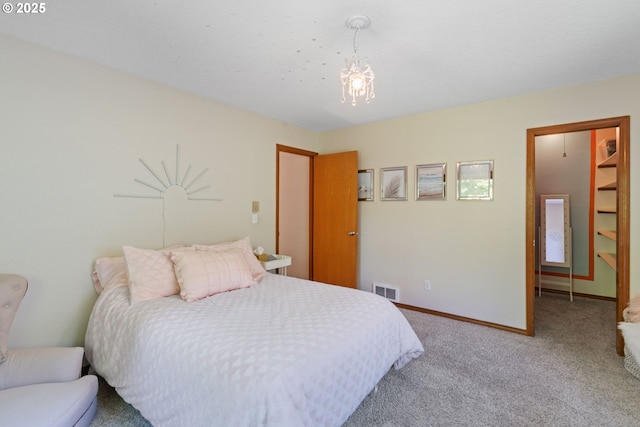 carpeted bedroom featuring visible vents, baseboards, and an inviting chandelier