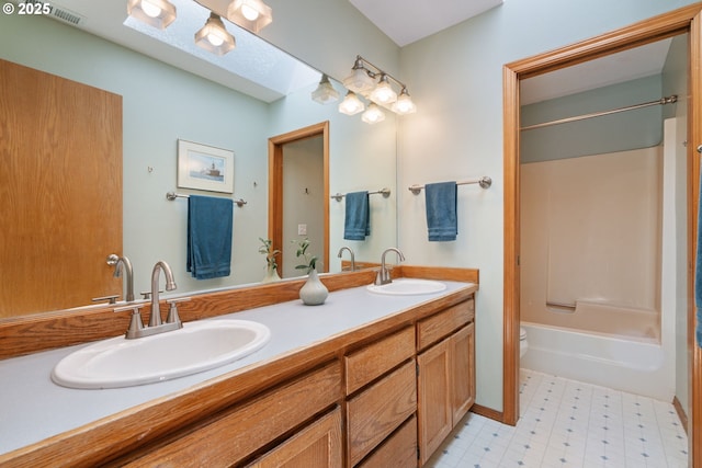 full bath with visible vents, a sink, double vanity, and  shower combination