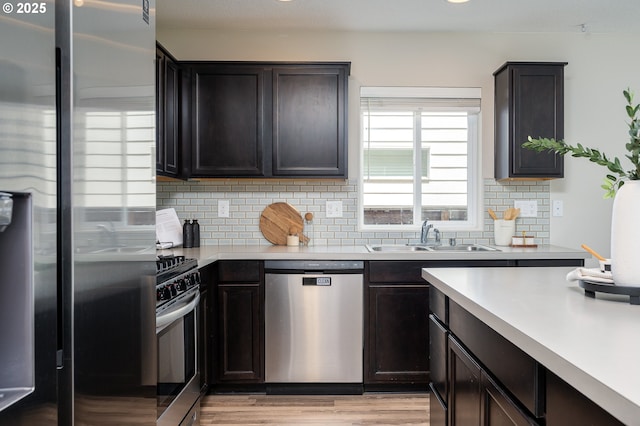 505 NE 138th Pl, Vancouver, WA 98684 - kitchen with appliances with stainless steel finishes, backsplash, light countertops, light wood finished floors, and dark brown cabinetry