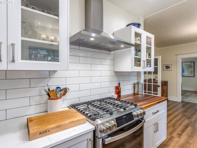 2820 SE 47th Ave, Portland, OR 97206 - kitchen with wooden counters, glass insert cabinets, wall chimney range hood, backsplash, and gas stove