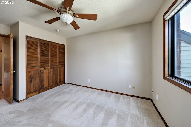unfurnished bedroom with light carpet, baseboards, and multiple windows