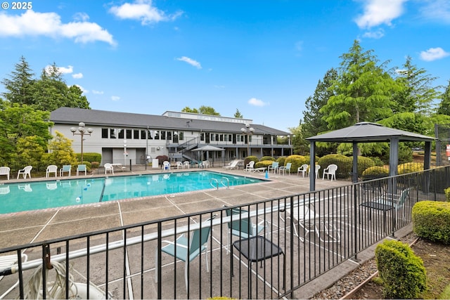 pool with fence, a wooden deck, a gazebo, a patio area, and stairs