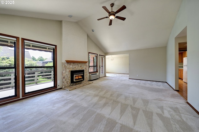unfurnished living room with high vaulted ceiling, baseboards, ceiling fan, light carpet, and a warm lit fireplace