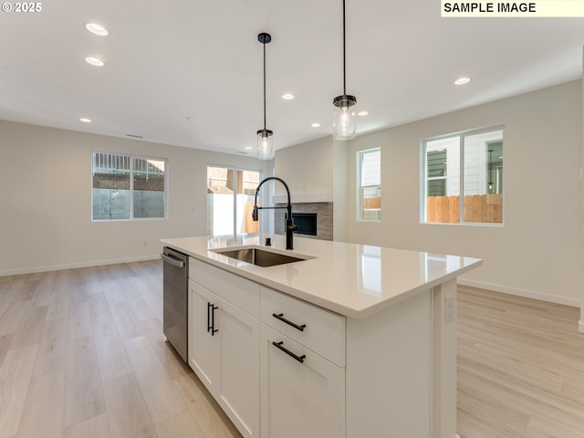 kitchen featuring plenty of natural light, a sink, and light wood-style floors