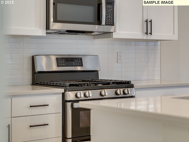 kitchen featuring appliances with stainless steel finishes, light countertops, white cabinetry, and tasteful backsplash