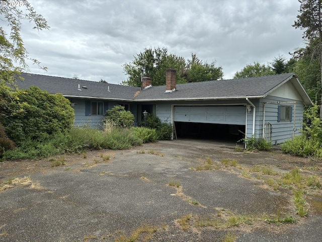 33962 Church Rd, Warren, OR 97053 - view of front facade featuring an attached garage, a chimney, and driveway