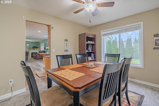 dining space featuring a ceiling fan, baseboards, and a textured ceiling