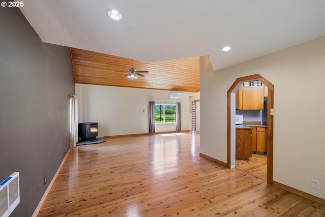7980 Kilchis River Rd, Tillamook, OR 97141 - unfurnished living room with a wood stove, recessed lighting, light wood-style floors, baseboards, and a wall mounted air conditioner