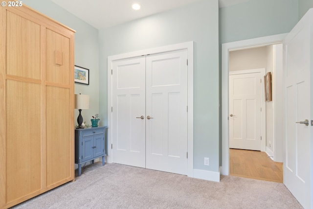 unfurnished bedroom with carpet floors, a closet, recessed lighting, and baseboards
