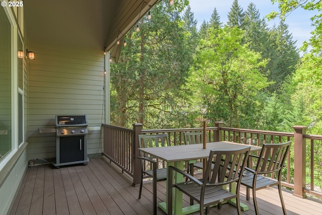 wooden terrace featuring outdoor dining area and a grill