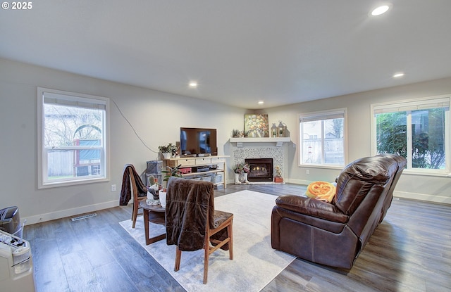 living room featuring hardwood / wood-style floors, plenty of natural light, and a tile fireplace