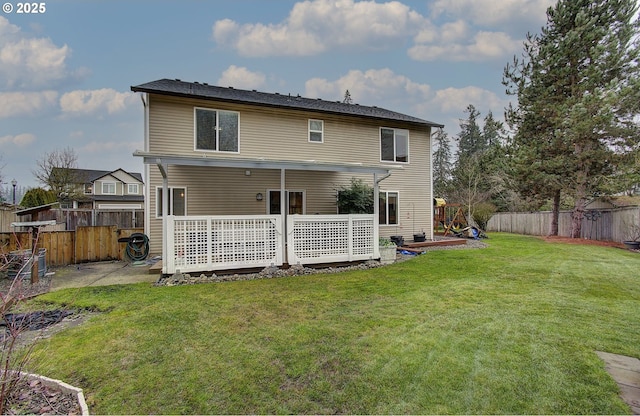 rear view of property featuring a deck and a lawn