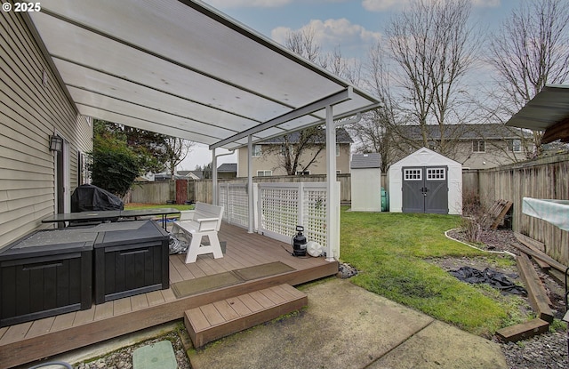 wooden terrace featuring a storage shed, a yard, and a grill