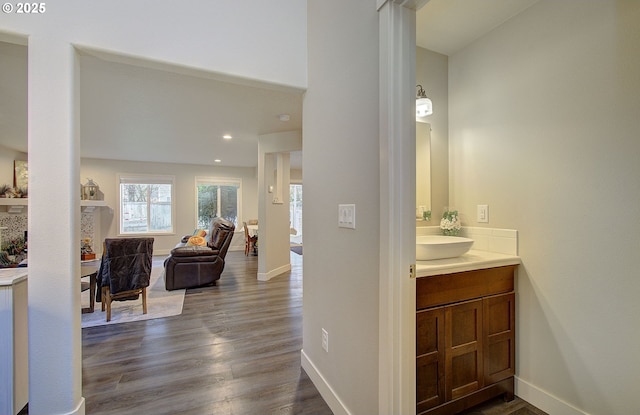 corridor with sink and hardwood / wood-style floors