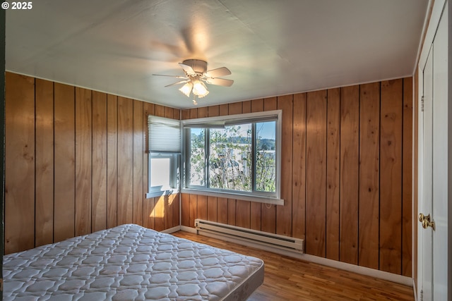 164 Pippin Ave, Roseburg, OR 97471 - bedroom featuring a baseboard heating unit, baseboards, wood finished floors, and wooden walls