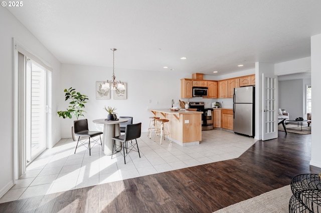 5700 NE 82nd Ave Unit C15, Vancouver, WA 98662 - kitchen featuring a notable chandelier, light wood-style flooring, appliances with stainless steel finishes, and a peninsula