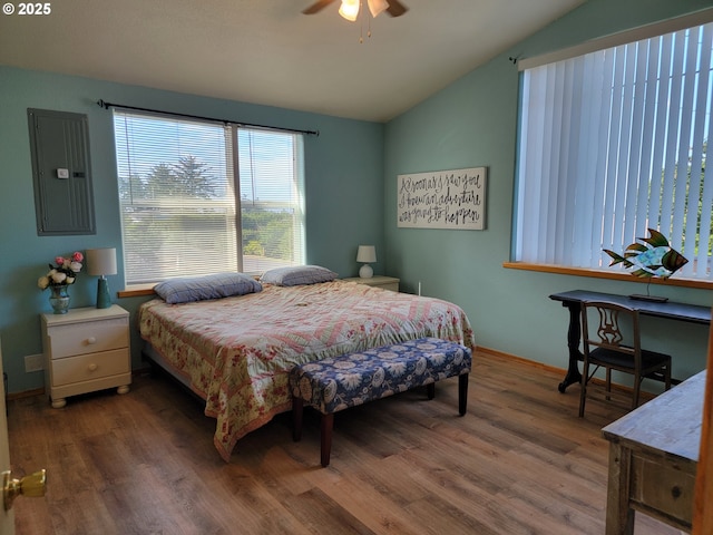 bedroom featuring electric panel, baseboards, wood finished floors, and lofted ceiling