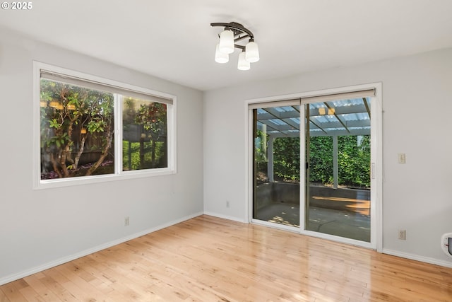 spare room with wood finished floors and baseboards